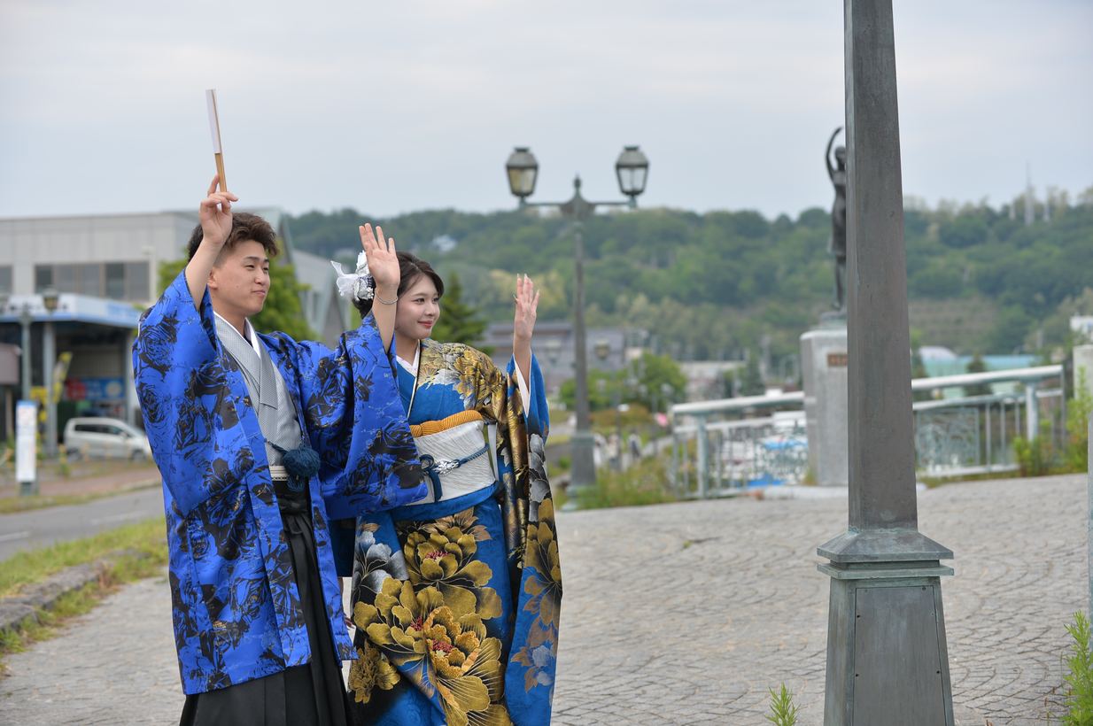 坂道で両手を広げるふたり